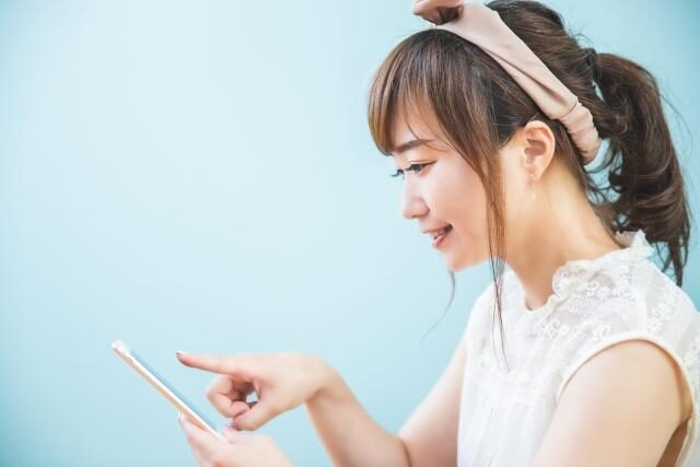 未経験から産業保健師を目指す女性が、気になる求人にスマホから問い合わせしているイメージ