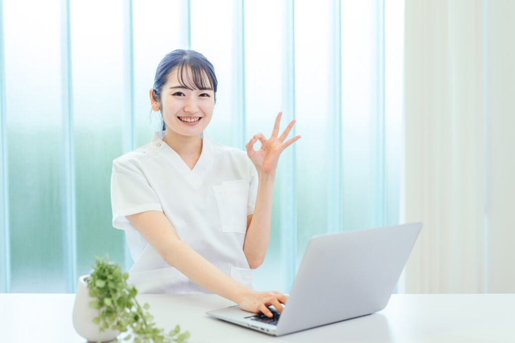 パソコンの前でOKサインをする笑顔の女性看護師のイメージ。看護roo!の基本情報やサービス内容を紹介する場面