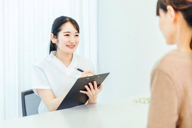 カウンセリングシートを手に笑顔で話す女性スタッフ。メディカルブロー2回目の施術前の説明をイメージした写真