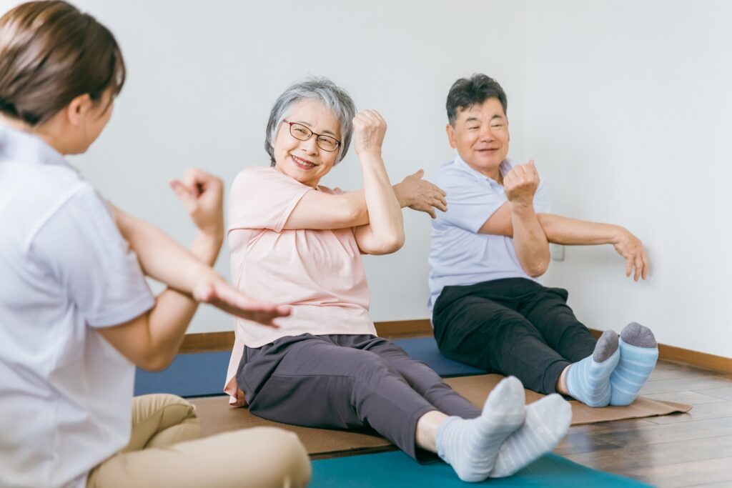 機能訓練指導員として働くイメージ（高齢者施設の体操・歩行練習）